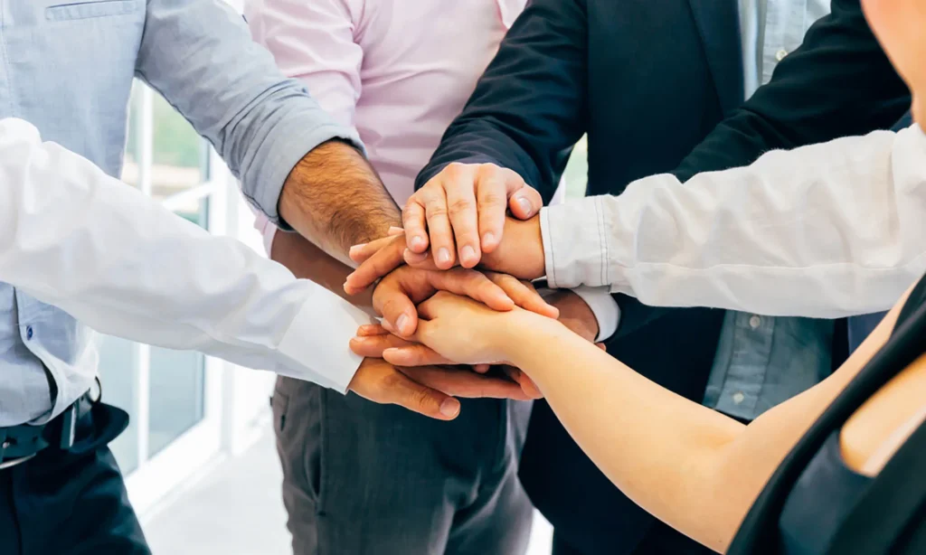 Business people putting hands togehter for unity